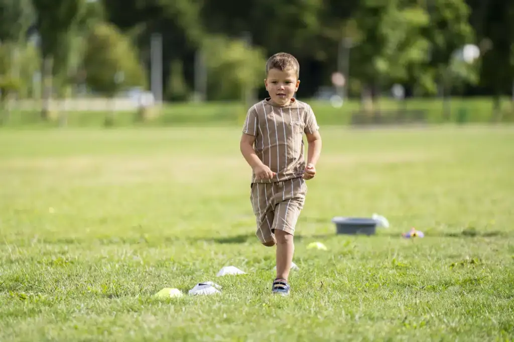 Jongetje dat rent over het sportveld