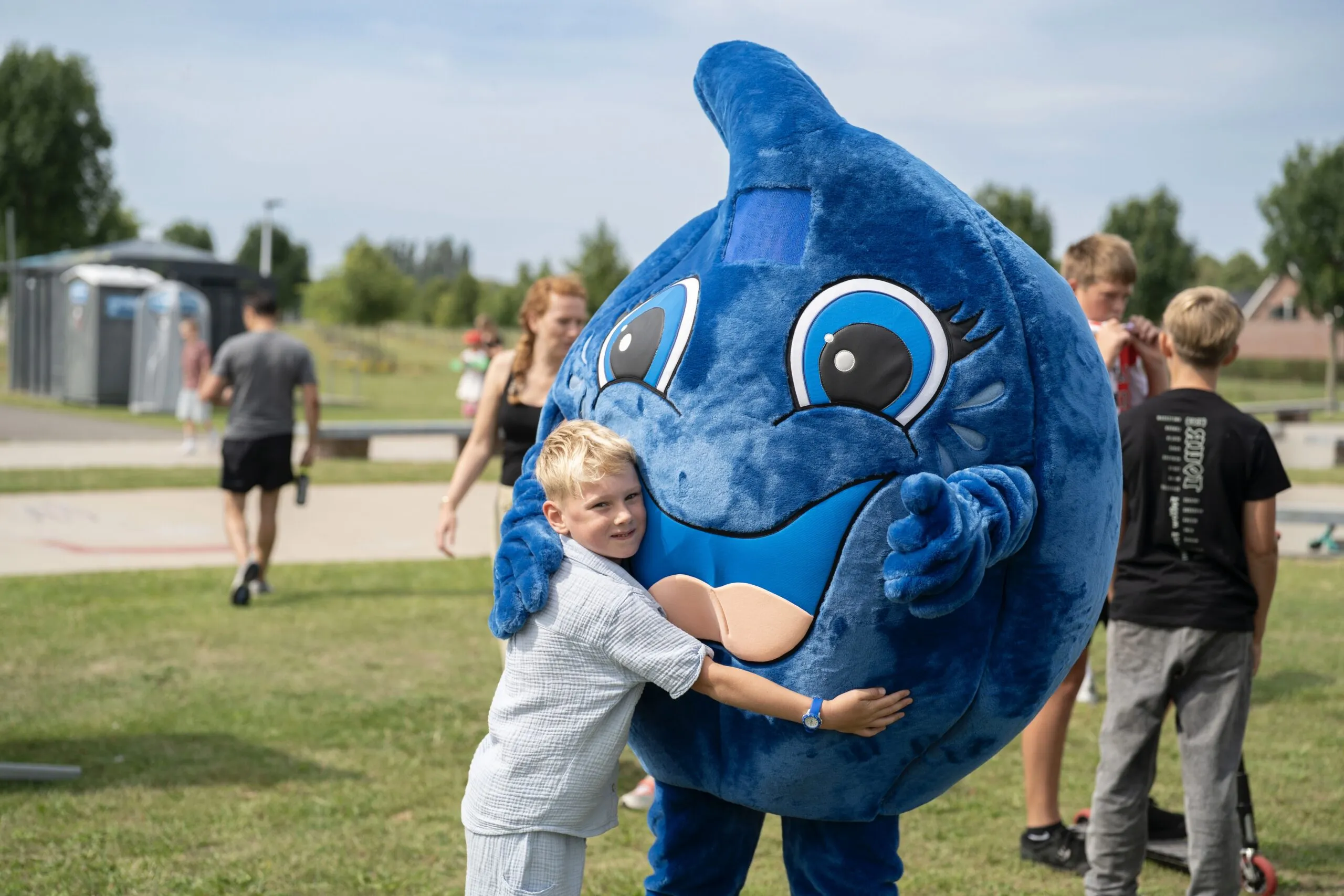 Druppie, de mascotte van JOGG, samen met een kind op het Urban Event