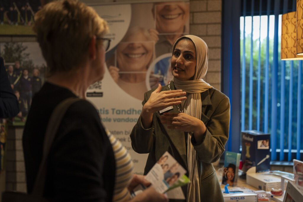 Partner die iets uitlegt over haar organisatie op een vitaliteitsdag