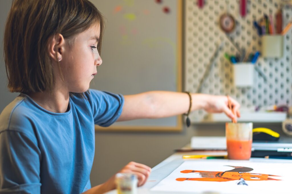Jonge meid die op school aan het schilderen is