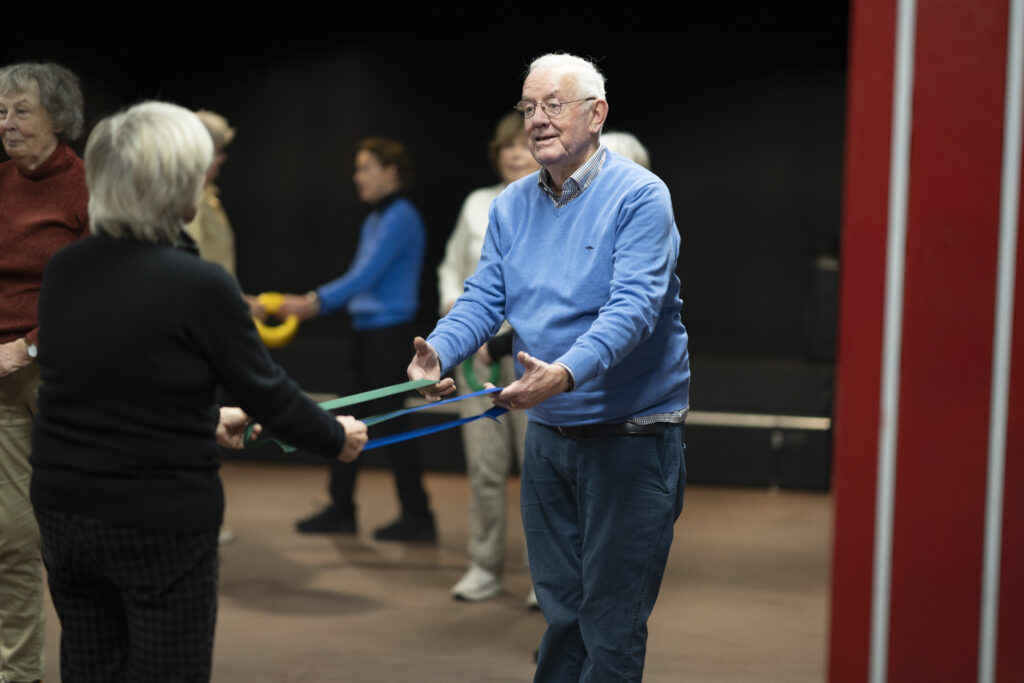 Twee ouderen die meedoen met een valpreventieles